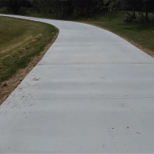 A long winding concrete driveway.