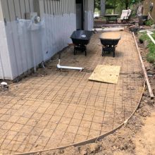 An exposed aggregate concrete walkway under construction.